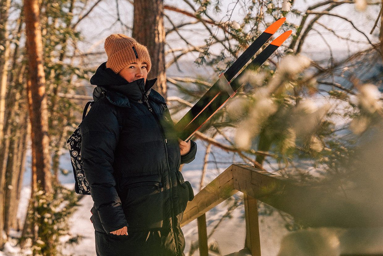 Henkilö kantaa kainalossaan suksia talvisessa maisemassa. Porokylän Leipomon sosiaalinen media ja sisällöntuotanto rakentuu Huhu Digitalin suunnittelemana ja toteuttamana.